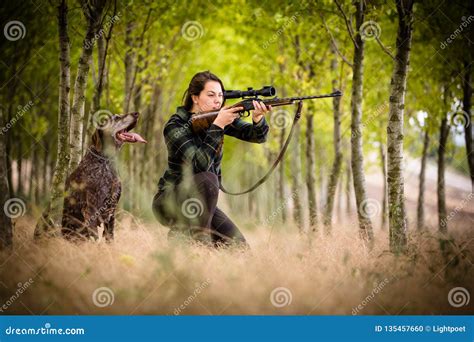 Woman hunter in the woods stock photo. Image of activity - 135457660