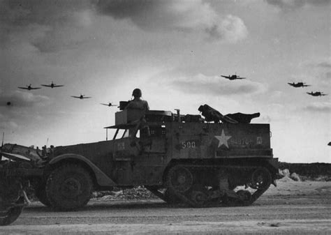 Strange Beauty in Warfare: A squadron of P-47 Thunderbolts flies over an American half-track ...
