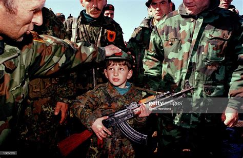 UÇK - Kosovo‘s Liberation army handing a gun to a young boy, in a rally ...