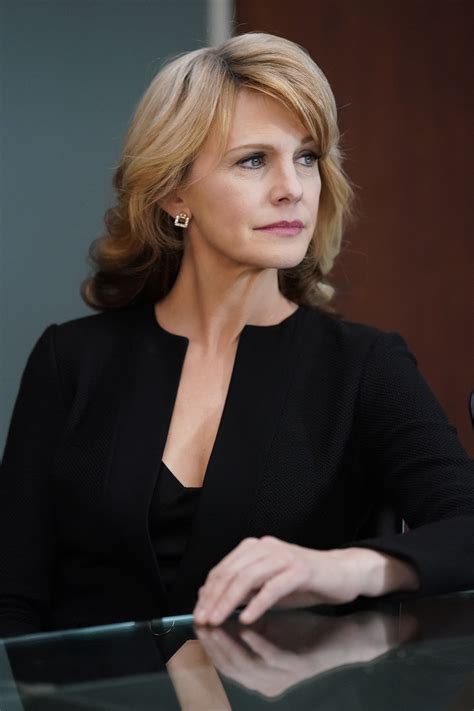 a woman sitting at a glass table in front of a microphone