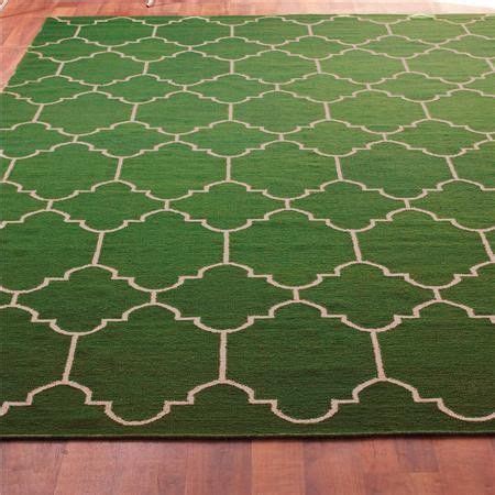 a green area rug with white trellis on it