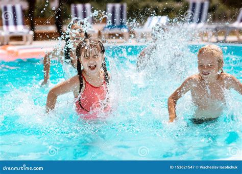 Children Laughing while Splashing Water in Swimming Pool Stock Image ...