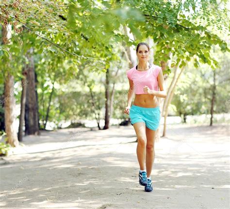 Woman jogging at park Stock Photo by ©belchonock 52340035