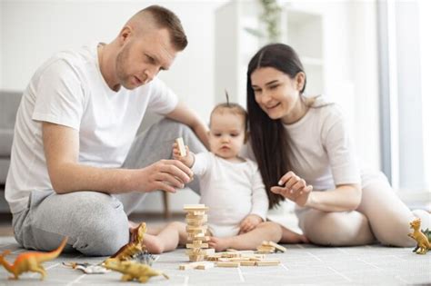 Premium Photo | Happy parents playing with toddler using wooden blocks