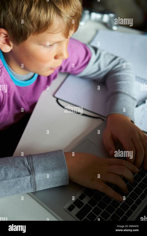 Boy Studying In Bedroom Using Laptop Stock Photo - Alamy