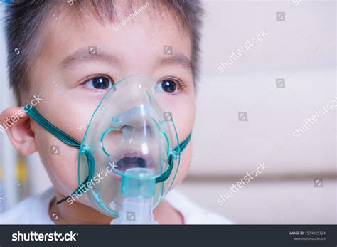 Closeup asian face little children boy sick he using steam inhaler nebulizer mask inhalation ...