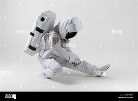 Astronaut stretching before exercise, white background Stock Photo - Alamy