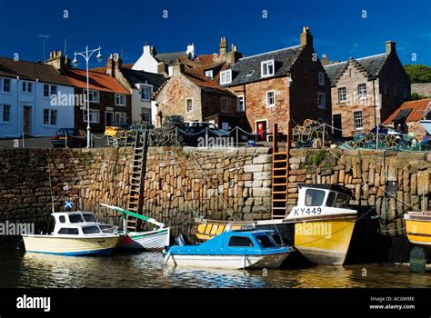 Small boats in old harbour in traditional fishing village of Crail in ...