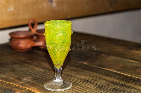 A Green Wine Glass Sits on a Wooden Dining Table. Stock Photo - Image ...