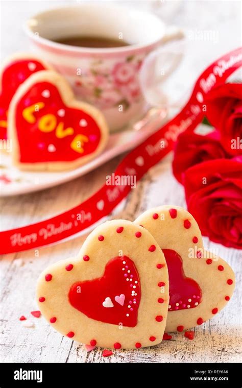 Homemade Valentines day heart cookies red roses cupof coffee on rustic white background ...