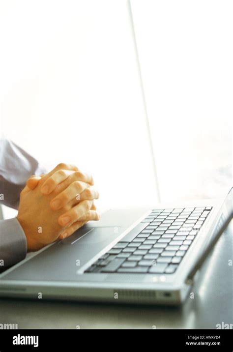 Businessman's folded hands on top of keyboard, close-up Stock Photo - Alamy