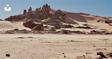 A desert landscape with a mountain in the background photo – Free ...