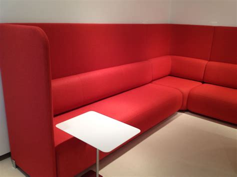 a red couch sitting next to a white table