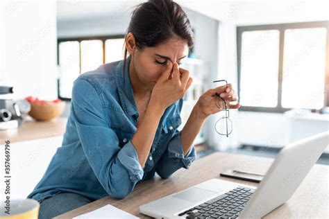 Stressed business woman working from home on laptop looking worried ...