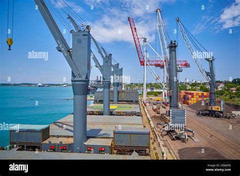 Operations with coal in seaport. Loading coal on bulk carrier. Coal loading by cranes on bulk ...