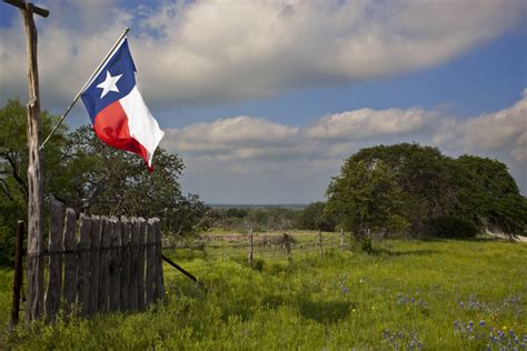 a-texas-flag-proudly-flies-from-the-gate-entrance-at-a-texas-hill ...