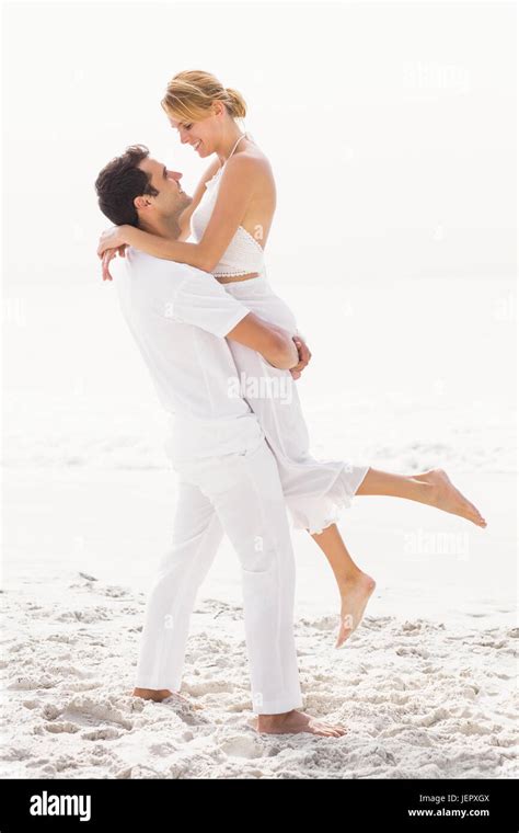 Man lifting woman on the beach Stock Photo - Alamy