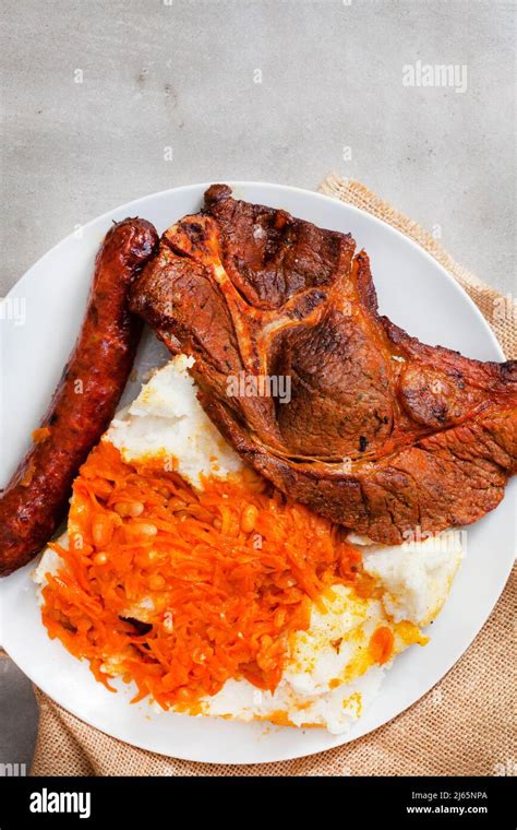 Flat lay of Traditional South African Braai or Shisa nyama, meat cooked on an open flame and ...