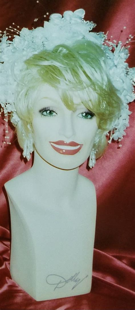 a mannequin head with white flowers in it's hair and blue eyes