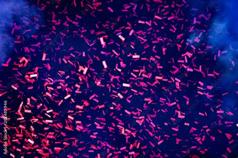 Hundreds of confetti fired on air during a festival at night. Image ideal for backgrounds. Blue ...