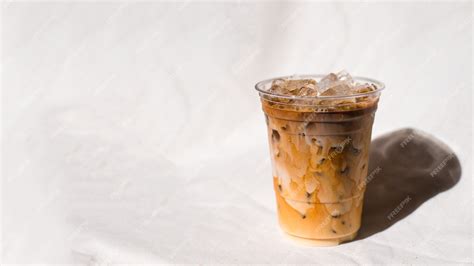 Premium Photo | Closeup plastic cup of iced coffee with milk on the table