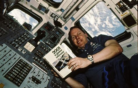 Astronaut Thomas D. Jones Holding Copy of 2001 A Space Odyssey During STS-98