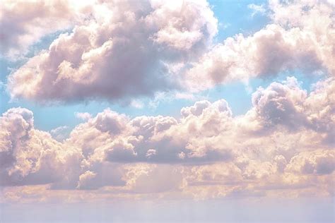 Illuminated fluffy pink clouds in a blue sky Photograph by Artpics