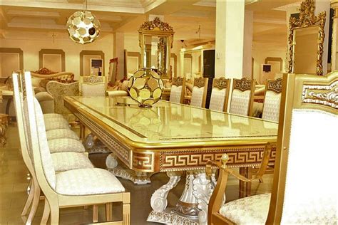 an ornate dining room table surrounded by white upholstered chairs and ...