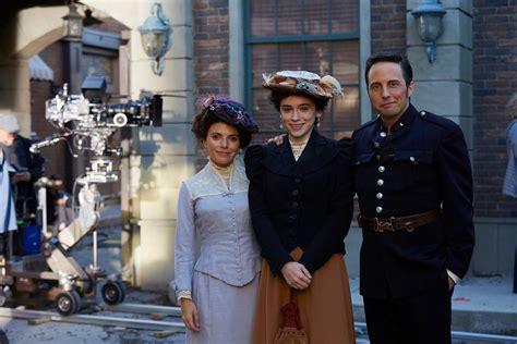 three people standing next to each other in front of an old building ...