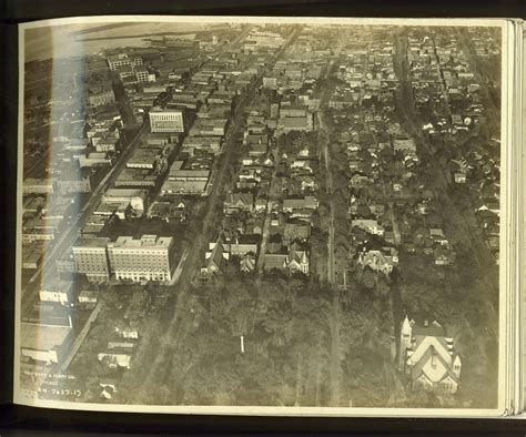 an old black and white photo of a city with lots of buildings in the middle