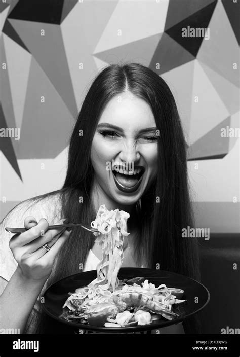 Beautiful woman with expressively opened mouth eating fettuccine Stock Photo - Alamy