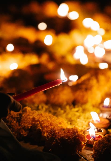 Close Up Photograph of Person Praying in Front Lined Candles · Free Stock Photo