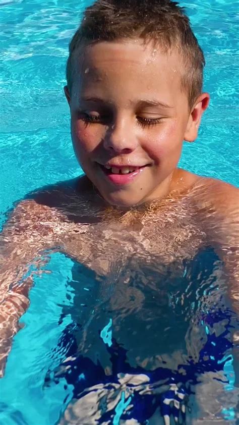 A boy bathes in a pool of blue water. Su... | Stock Video | Pond5
