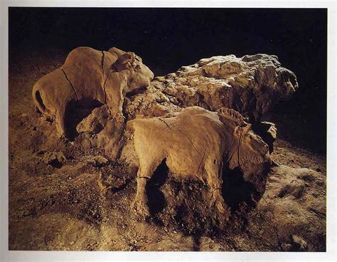 two elephants standing next to each other on top of a rocky hill covered in dirt