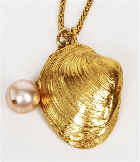 This necklace is strung with a meticulously crafted pendant in the shape of a clam shell ...