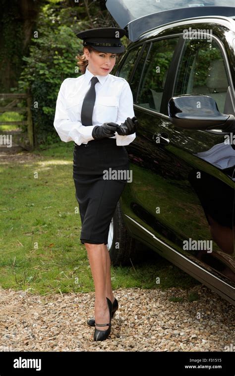 Woman chauffeur putting on her uniform black leather gloves Stock Photo - Alamy