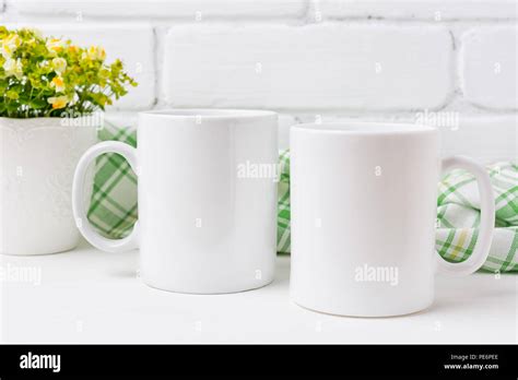 Two white coffee mug mockup with small yellow and green flowers. Empty mug mock up for design ...