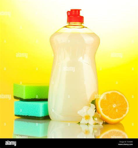 Dishwashing liquid with sponges and lemon with flowers on yellow background Stock Photo - Alamy