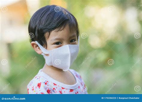 Child Wearing a Protective Face Mask on a City Street with Air ...