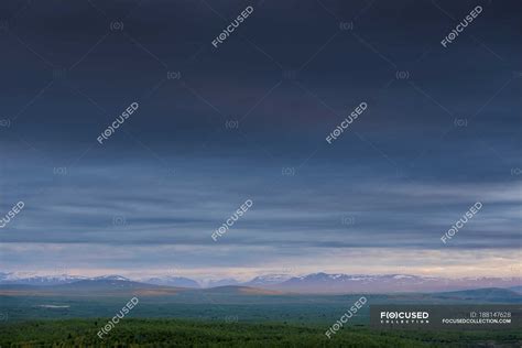 Landscape view of mountain range on horizon and moody sky — overcast ...