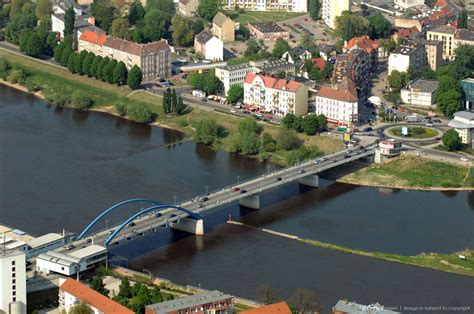 an aerial view of a bridge spanning the width of a river with buildings ...