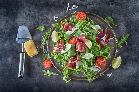 Dried beef bresaola. Salad bresaola arugula baby spinach tomatoes lime and cheese parmesan ...