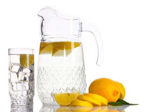 Premium Photo | Pitcher and glass of lemonade and lemon isolated on white