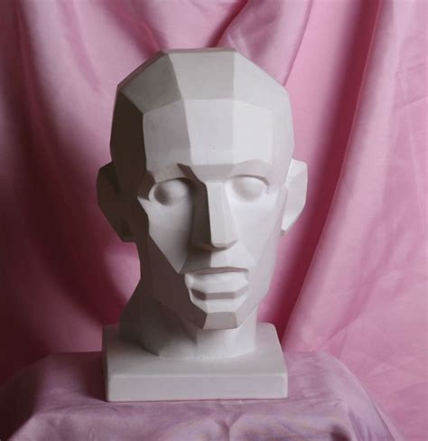 a white mannequin head sitting on top of a pink cloth covered tablecloth