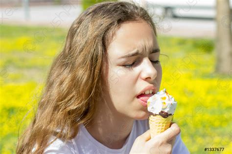 Beautiful teen girl eating ice cream in a waffle cone - stock photo 1337677 | Crushpixel