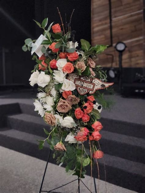 an arrangement of flowers is displayed on a stand