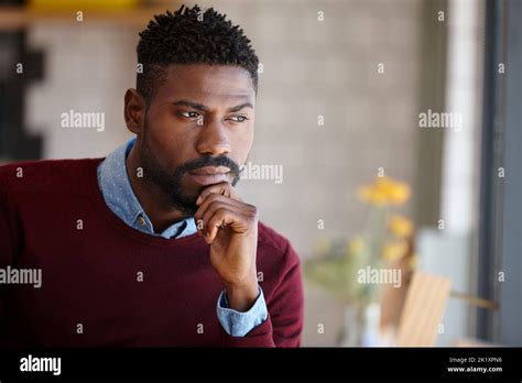 Hes waiting for someone. A young african man sitting in a coffee shop Stock Photo - Alamy