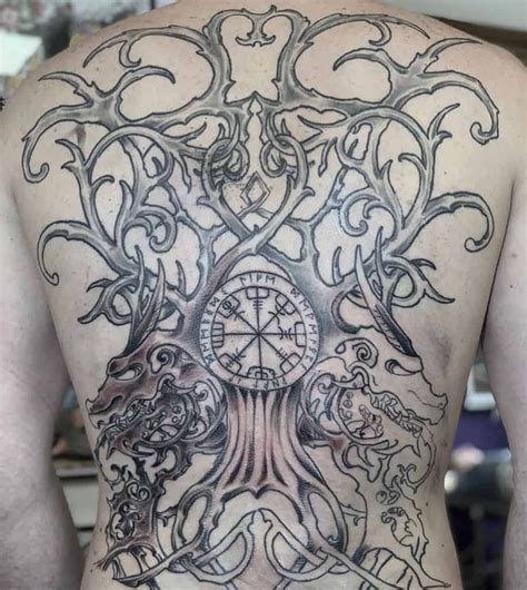 the back of a man with tattoos on his body and an image of a tree