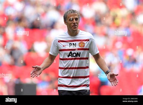 Manchester United coach Phil Neville on the pitch before the match ...