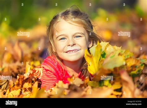 Happy little girl plays with autumn leaves Stock Photo - Alamy